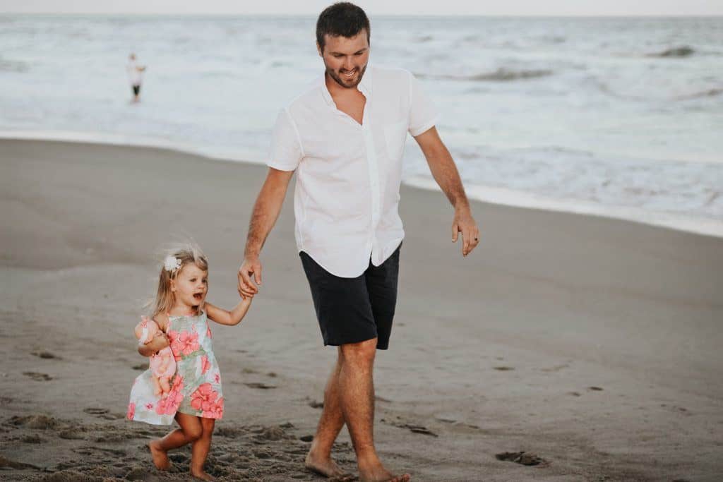 Eduquer Avec Sagesse - pere marchant sur la plage en prenant sa fille par la main - photo de carly-rae-hobbins-sur unsplash
